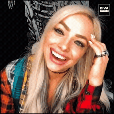 A Woman Wearing A Plaid Shirt And A Ring Is Smiling For A Diva Photo GIF