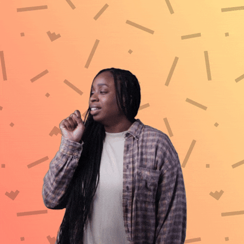 A Woman Wearing A Plaid Shirt Is Standing In Front Of A Patterned Background GIF