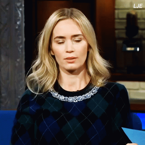 A Woman Wearing A Plaid Sweater Has The Letters Lje On The Bottom Right GIF