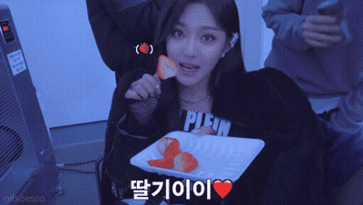 A Woman Wearing A Plein Sweatshirt Eating Strawberries GIF