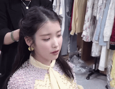 A Woman Wearing A Purple Dress With Pearls On It GIF