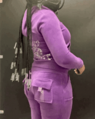 A Woman Wearing A Purple Hoodie And Pants With Rhinestones On The Back GIF