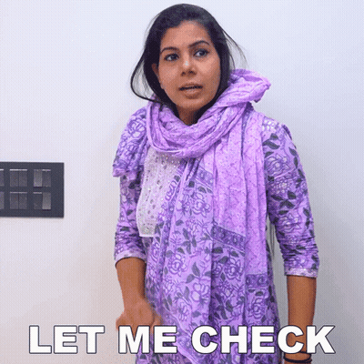 A Woman Wearing A Purple Scarf And A Purple Shirt Says Let Me Check GIF