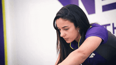 A Woman Wearing A Purple Shirt With The Letter W On The Front GIF