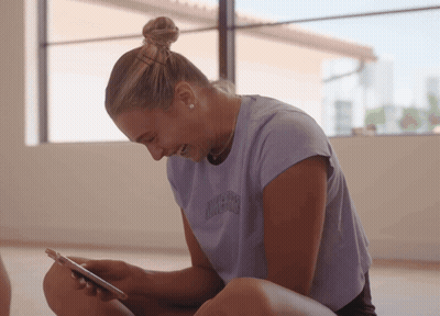 A Woman Wearing A Purple T-Shirt That Says California On It GIF