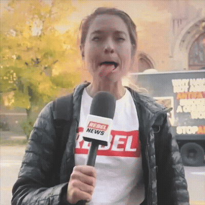 A Woman Wearing A Rebel News T-Shirt Is Holding A Microphone GIF