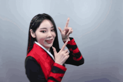 A Woman Wearing A Red And Black Jacket Is Pointing Up GIF