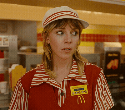 A Woman Wearing A Red And White Striped Mcdonald 'S Uniform With A Yellow Mcdonald 'S Badge GIF