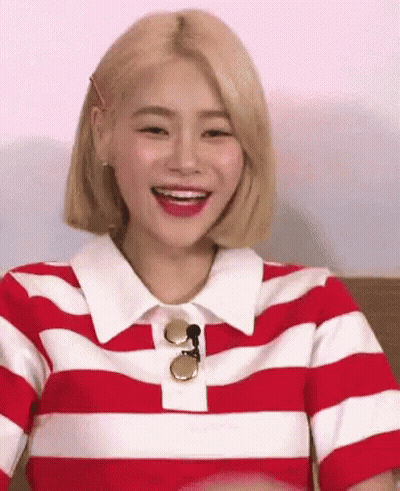 A Woman Wearing A Red And White Striped Shirt Is Smiling And Laughing . GIF