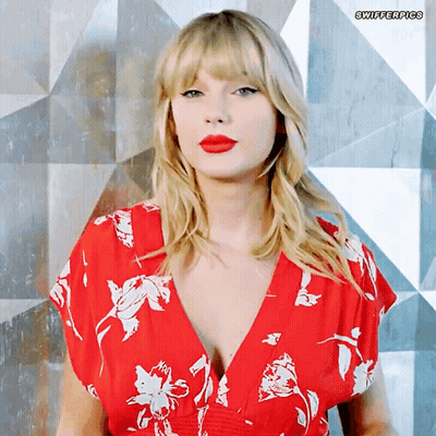 A Woman Wearing A Red Floral Dress With Swifterpics Written On The Bottom Right GIF
