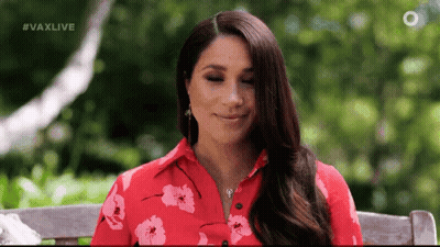 A Woman Wearing A Red Floral Shirt Is Sitting On A Bench . GIF