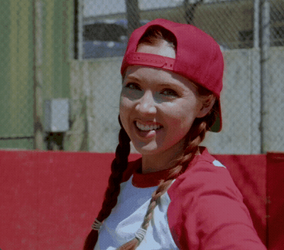 A Woman Wearing A Red Hat And A White Shirt Smiles At The Camera GIF