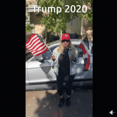 A Woman Wearing A Red Hat That Says Trump 2020 Stands In Front Of A Silver Car GIF