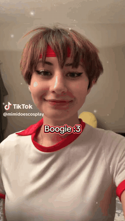 A Woman Wearing A Red Headband And A White Shirt Says Boogie On Her Face GIF