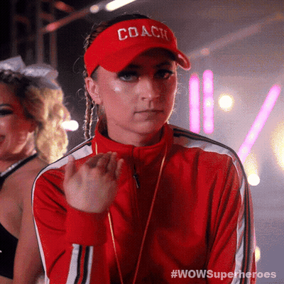 A Woman Wearing A Red Jacket And A Coach Hat GIF