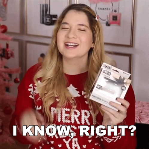 A Woman Wearing A Red Merry Christmas Sweater Is Holding A Star Wars Item And Says I Know Right GIF