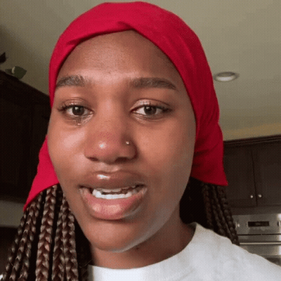 A Woman Wearing A Red Scarf Around Her Head GIF