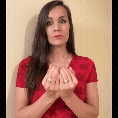 A Woman Wearing A Red Shirt With A Maple Leaf Pattern Holds Her Hands Together GIF