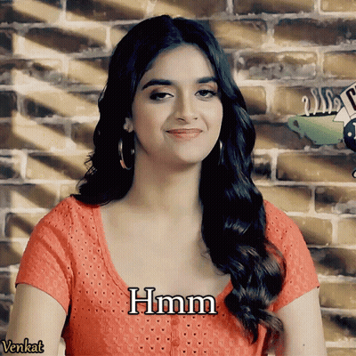A Woman Wearing A Red Shirt With The Word Hmm Written On It GIF