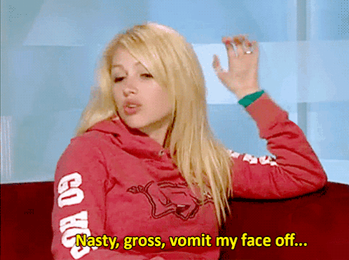 A Woman Wearing A Red Sweatshirt That Says Go Hawks On The Sleeves GIF