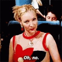 A Woman Wearing A Red Top With A Heart On It Says Oh No GIF