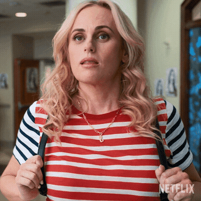 A Woman Wearing A Red White And Blue Striped Shirt Is Holding A Black Backpack With Netflix Written On The Bottom GIF