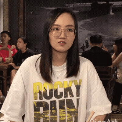A Woman Wearing A Rocky T-Shirt Looks At The Camera GIF