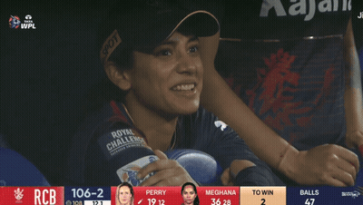 A Woman Wearing A Royal Challenge Jersey Sits In A Stadium GIF