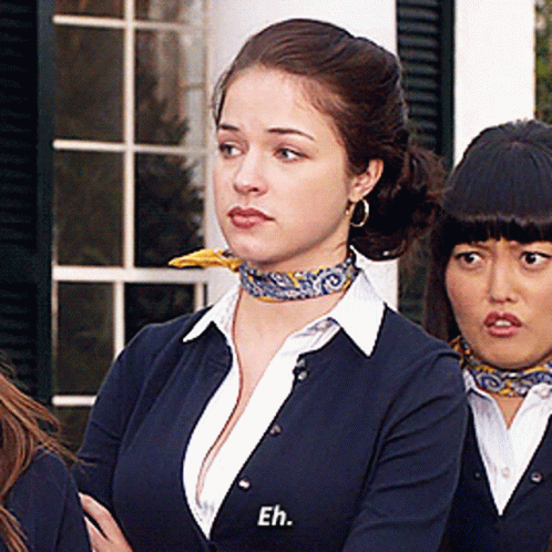 A Woman Wearing A Scarf Around Her Neck Has Eh Written On Her Sweater GIF