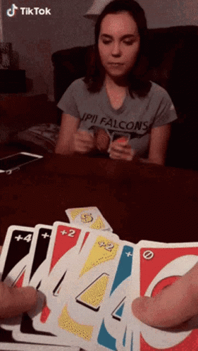 A Woman Wearing A Shirt That Says Falcons Is Playing Uno GIF