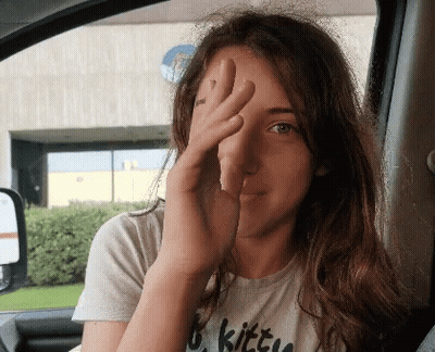 A Woman Wearing A Shirt That Says Kitty Covering Her Face GIF