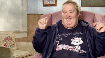 A Woman Wearing A Shirt That Says Royal Highness Is Sitting In A Chair GIF