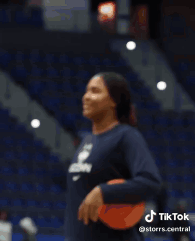 A Woman Wearing A Shirt That Says Uconn Is Smiling GIF