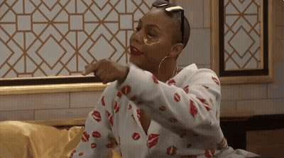 A Woman Wearing A Shirt With Kisses On It Is Pointing At Something GIF