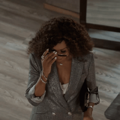 A Woman Wearing A Silver Jacket And Sunglasses Covering Her Face GIF