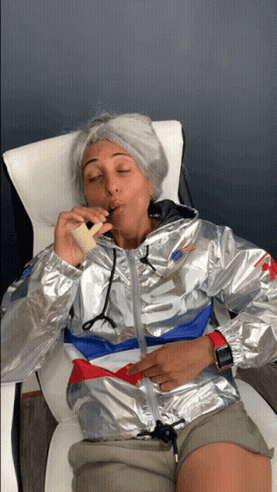 A Woman Wearing A Silver Nike Jacket Is Smoking An Electronic Cigarette GIF
