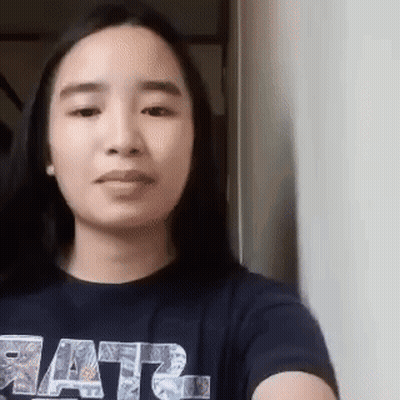 A Woman Wearing A Star Wars Shirt Is Taking A Selfie With Her Phone . GIF