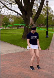 A Woman Wearing A Starlight Shirt Is Jumping A Green Rope GIF