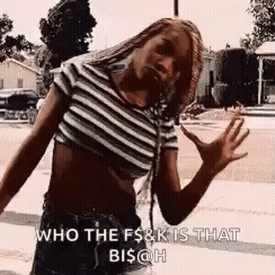 A Woman Wearing A Striped Crop Top And Shorts Is Standing On A Sidewalk . GIF
