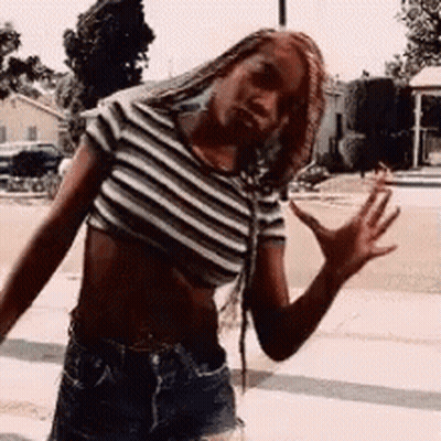 A Woman Wearing A Striped Crop Top And Shorts Is Waving Her Hand . GIF