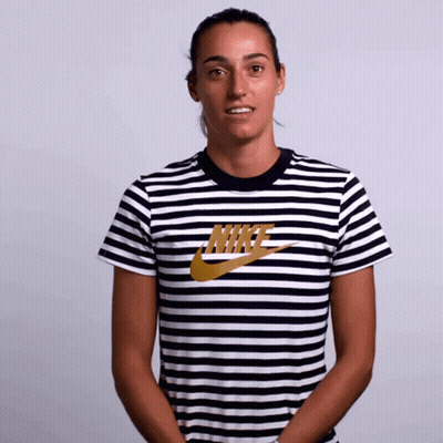 A Woman Wearing A Striped Nike Shirt Smiles GIF