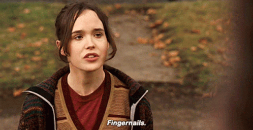 A Woman Wearing A Sweater And A Red Shirt Is Talking About Fingernails GIF