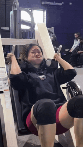 A Woman Wearing A Sweatshirt That Says ' Athletic ' On It Is Using A Machine GIF