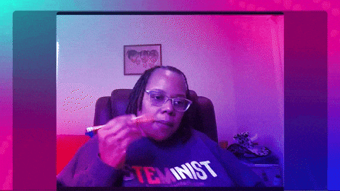 A Woman Wearing A Sweatshirt That Says Feminist Is Eating Something GIF
