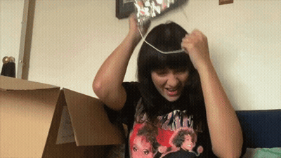 A Woman Wearing A T-Shirt That Says ' Ariana Grande ' On The Front GIF