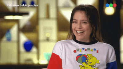 A Woman Wearing A T-Shirt That Says Masterchef Argentina Smiles GIF