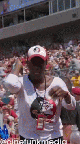 A Woman Wearing A Tampa Bays Hat Stands In A Crowd GIF