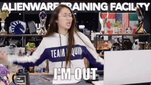 A Woman Wearing A Team Quid Sweatshirt Is Sitting In Front Of A Laptop GIF