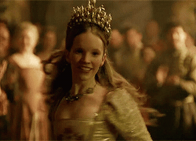 A Woman Wearing A Tiara And A Dress Is Smiling GIF