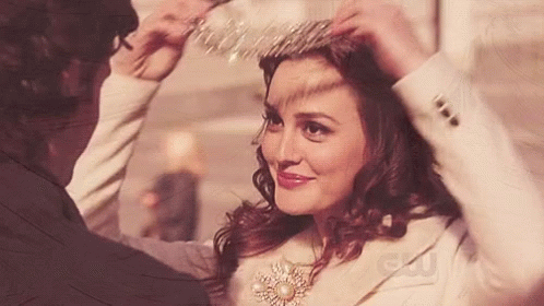 A Woman Wearing A Tiara Is Being Helped By A Man With A Cw Logo In The Corner GIF